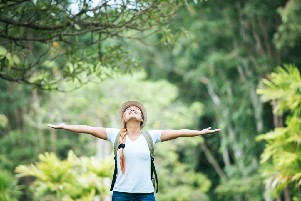 young happy woman with backpack raising hand enjoy with nature 1 1